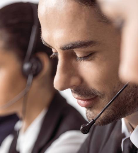 Close-up view of call center operators in headsets working together Close-up view of call center operators in headsets working together